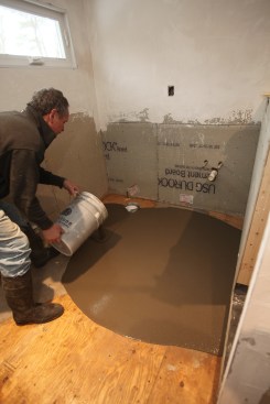 Author wears protective rubber boots as he adds a small batch of leveler to what was already poured.