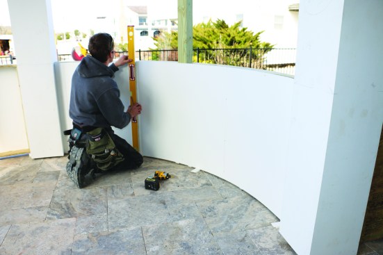 For the inside panels, the crew cuts the sheet stock to length and then springs it into place between the posts. As with the outside panels, the crew marks the locations for the studs.