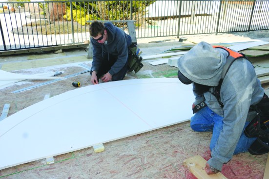 To lay out the location of the intermediate post, the crew snaps a line from the pivot point through the centerline of the arc.