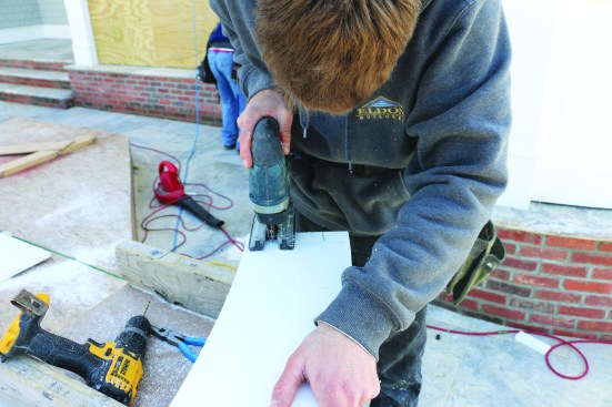After dividing the top cap into two pieces by cutting along the centerline, a worker uses a jigsaw to cut out the post.