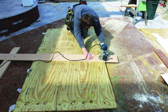 The crew cuts the curved plates from 3/4-inch treated plywood, using a router mounted on a strip of plywood to act as a trammel arm.