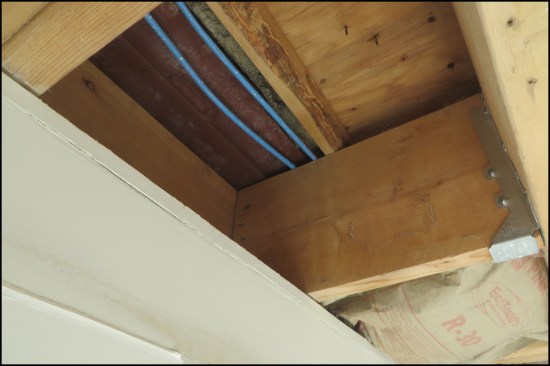 After 10 minutes of spraying, water appeared inside the house below the roof-to-wall juncture. (The homeowners had removed the drywall ceiling and batt insulation due to frequent leaking, exposing the steel angle supporting the stone veneer.)