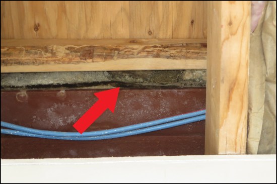 Water appeared at the bottom edge of the felt WRB, which terminated at steel angle shelf. The stone veneer was applied without through-wall flashing to direct water out of the wall above the roof.