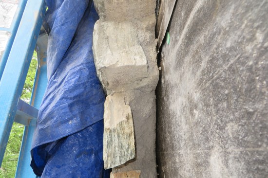 The existing mortar had been mixed up dry on site and so was very loose and porous. The stone had been laid up without an air space, which was code-legal for a brief while in the vicinity where the author works. Though it was common practice, it was not ideal from a water-management perspective. 