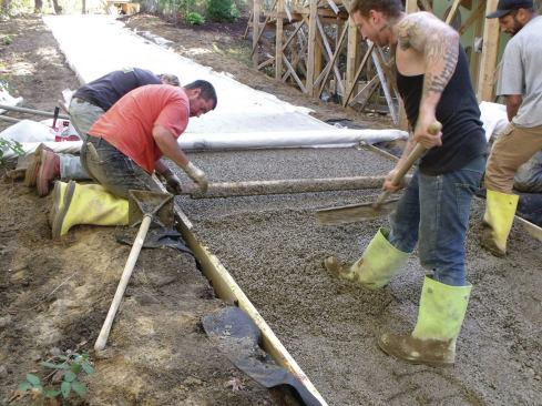 Workers distributed the fresh concrete with rakes.