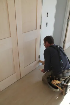 Shim the side jambs until the gaps between the slabs and along the top are perfectly even. The top corners of the door should align perfectly as well.