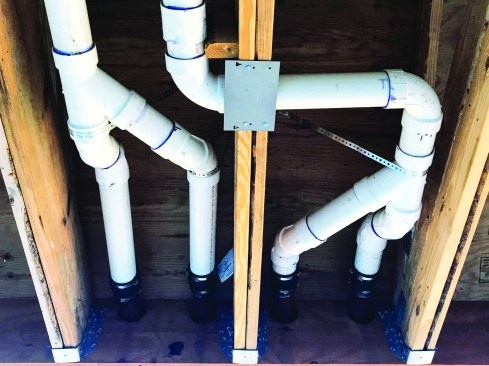 Multiple 3-inch drainage outlets Y together and step up to 4-inch runs through the soffit area.
