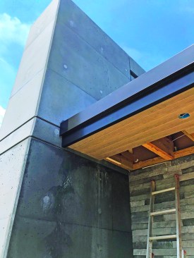 The roof was dried-in early; the tape was temporary until the roof could be installed. A two-piece fascia cap and T&G soffits finish off the installation. The entire gutter system is completely concealed.