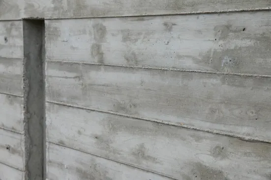 The grain and texture of the individual form boards telegraph in reverse onto the surface of the concrete.
