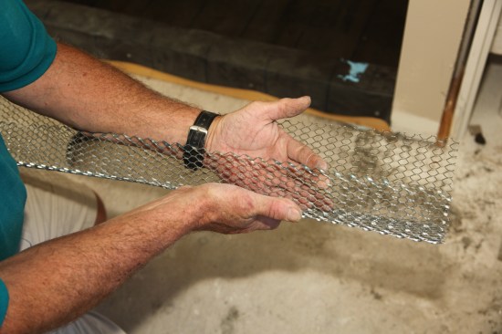 Hold the wire 1 1/2 inches off the bottom of the shower pan, with the factory edge (without sharp edges that could puncture the membrane) on the inside of the pan. 