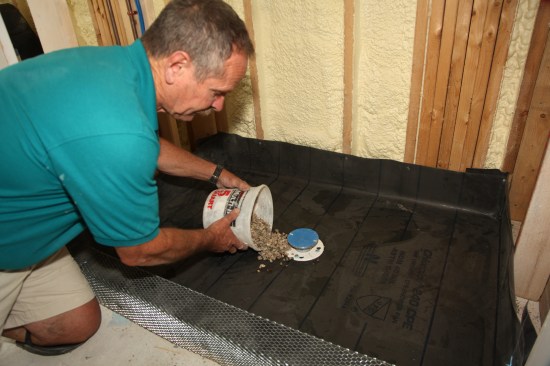 To keep the weep holes in the drain clear, spread a small amount of pea stone around the base of the drain. 