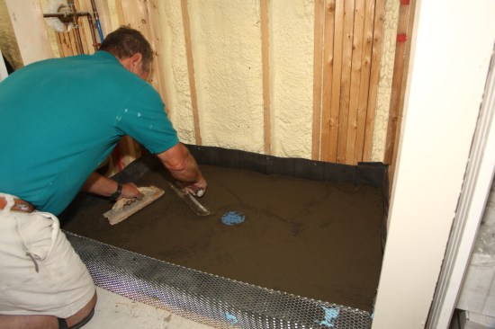 Pack the mortar tight to the membrane, especially in the corners, along the perimeter of the shower, and around the drain. Smooth the mixture using a wood float and a steel floating trowel.