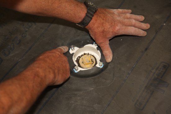Cut out the center of the membrane by letting the knife follow the inside ring of the drain. Then press the membrane into the sealant that was spread earlier.