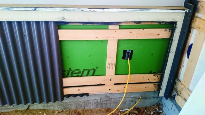 A second horizontal layer of furring provides nailing for vertically applied siding, such as this corrugated metal.