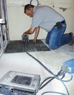 A technician uses ground-penetrating radar to map the position of electrical conduits and other obstructions in the reinforced slab floor.