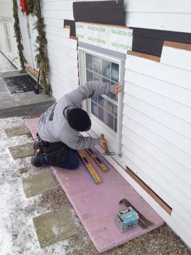 After confirming that the window is level and centered, Manny nails off the two bottom corners.