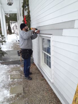 Manny pre-drills lengths of new preprimed clapboards that will be secured with stainless steel nails.