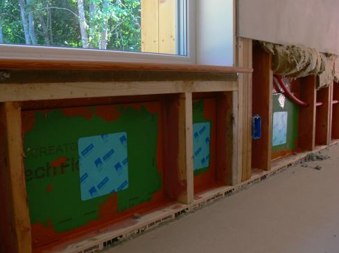 A completed, air-sealed patch in the home's OSB sheathing air control layer after removal of wet insulation and installation of new cellulose.
