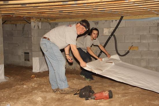 Workers from Energy One America start to lay a ten-mil poly ground cover in the crawlspace of a new house on Daniel Island in Charleston, South Carolina.