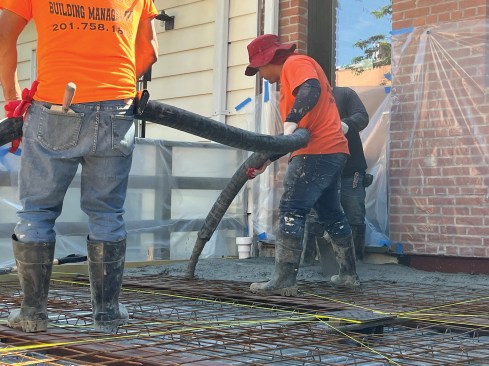 The workers continue the pour to the string lines. 