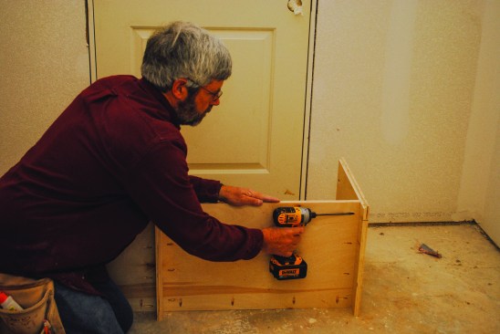The base section assembles much like the upper section except that it is shorter and deeper. The author attaches the bottom shelf 4 inches from the bottom of the box to create a kick space.