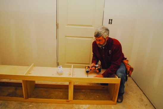 A spreader cleat along the top of the cabinet provides attachment for the plywood back, as well as support for the upper section when it is installed. The face frame attaches to the box with glue and pocket screws, and the plywood back completes the assembly