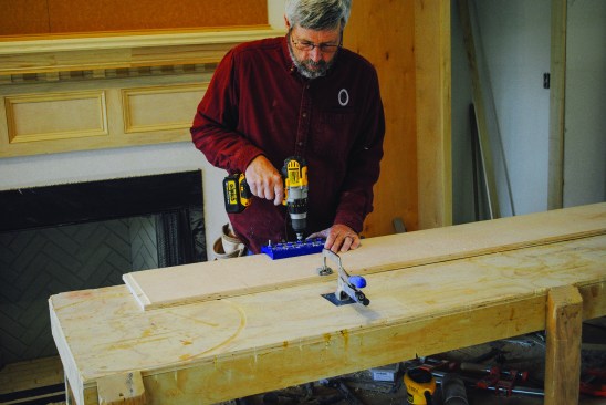 A jig positions holes along the edges for adjustable shelf brackets.