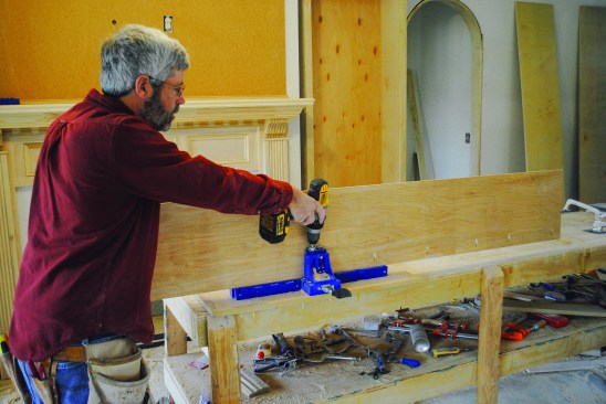 The author drills pocket holes along the front edge of the vertical components for attaching the face frame.