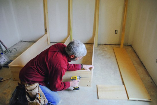 He screws the box together, fitting the top pieces into the rabbets he cut into the top edges of the verticals.
