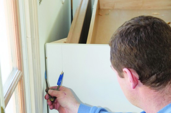 A second common application for scribing is fitting a cabinet to a wall when the wall is not perfectly plumb.