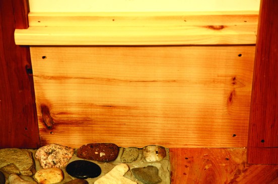 Another place for a scribe is fitting trim to an uneven surface. Here a section of baseboard has been scribed to the beach stones in the floor. Read further to find out how this scribe was done.