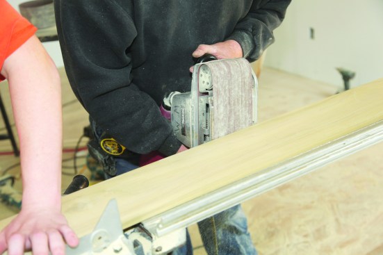 For small straight scribes, remove waste with a belt sander. A hand plane can also be used. Add a slight back bevel to the cut to make fine-tuning go more quickly.