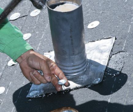 Vent stacks are sealed with prefabricated lead flashings, which are set in asphalt cement.