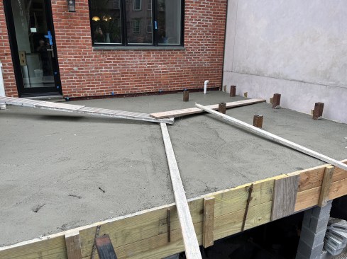 The slab will be finished to slope the center drain. The stubs to connect to the fire escape can be clearly seen. 