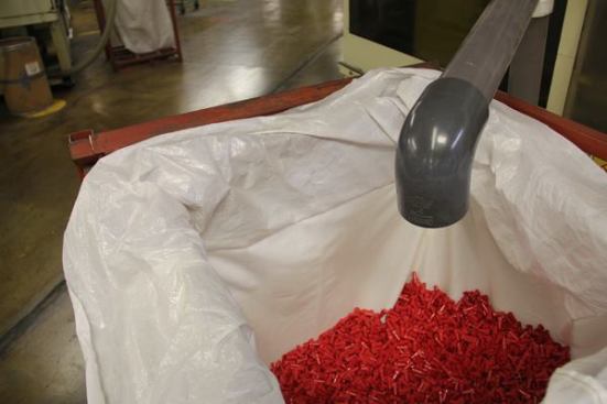 Bodies for winged WIRE-NUT connectors are made in an injection molding machine, dropped into a hopper, and blown out through a pipe and into a bag.