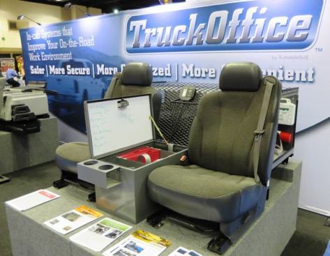 The TruckOffice replaces the console and jump seats found in extended cab trucks. The console replacement is a lidded box with places for office supplies and files. The area behind is an enclosed platform where tools and other supplies can be stored. This one is mostly metal. A second version, made from blow molded plastic has hinged lid compartments in the section behind the seats. Both versions can be outfitted with 120V receptacles and an inverter.