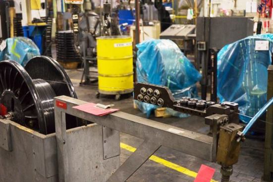 The edge-wire passes through straightening rollers before being fed into an electron beam welding machine.