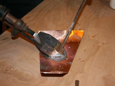Spread flux, and then melt enough solder to spread evenly on all four facets of the tip.