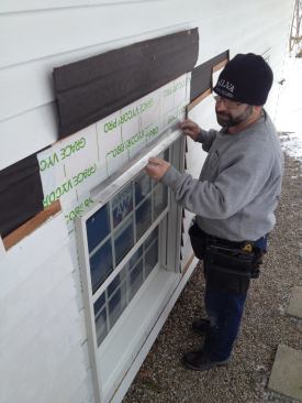 Manny installs the first of two pieces of drip cap specified by the manufacturer.