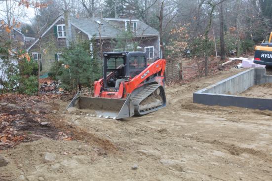 With a gentle touch on a tough machine, George eases a high point on the existing grade into the new grade around the foundation.