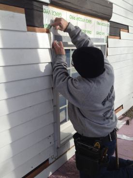 The window manufacturer specifies that the side flashing tape extend 2 inches past the upper nailing flange of the window. Manny extends the tape past the flange almost 4 inches on both sides.