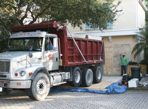 For convenience, the authors use dump trucks for roof tear-offs, backing them as close to the house as feasible.
