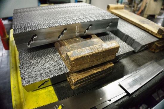As soon as the teeth are set the stock enters a machine that punches the blanks that will be turned into hole saws—the longer the blank the larger the diameter. I was not allowed to photograph the punching process. As you can see, the blades come out of the machine with the cutouts and stamped lettering already done.