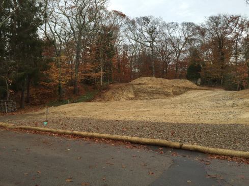 To keep the construction mess contained on site and out of the street, as well as out of neighboring properties, the team uses different erosion control measures. Along the road, a wide shallow trench is dug out and filled with crushed stone to catch dirt and mud from construction vehicles. In addition, a straw wattle is staked down to absorb run off and to catch silt.