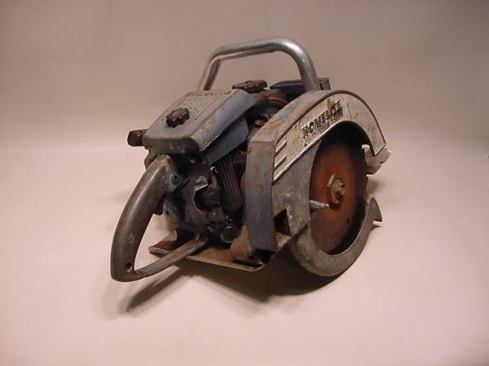 When viewed from the rear it becomes clear that this is chainsaw motor with a base plate and circular blade housing attached.