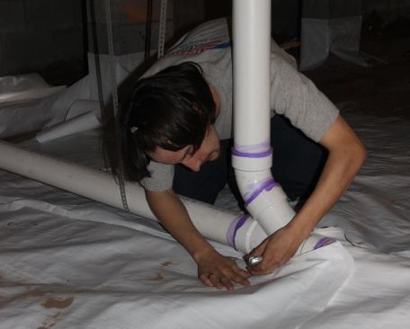Penetrations where plumbing passes through the ground vapor barrier receive particular attention. This joint will be thoroughly sealed with vapor-tight tape.