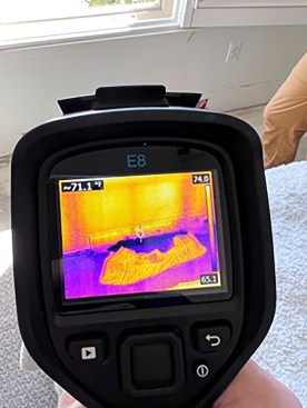 A thermographic view of the opened wall section shown in the previous photo shows extensive wetting  (purple) of the slab. Had the slab been dry, the edges nearest the exterior would be cooler (pink) than the wall but not as cool as they are when wet.