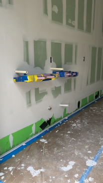 The installed fiberglass-mat boards are taped in with the rest of the drywall, so they completely disappear into the wall.