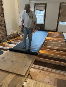By rolling it out over plywood, a crew member was able slide it into position.