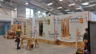 The apprentices practice large-scale projects in an open shop. Not being subject to the weather is a nice change for them. While not quite the same as being on site, working in a controlled environment allows for mistakes (learning opportunities) to happen under supervision. Similar setups to this exist in colleges and union training centers across Canada.
